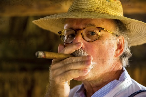 Hans Blossey Tourist smokes a Havana cigar, Tobacco farm in the Vinalestal, Viñales, Cuba, Pinar