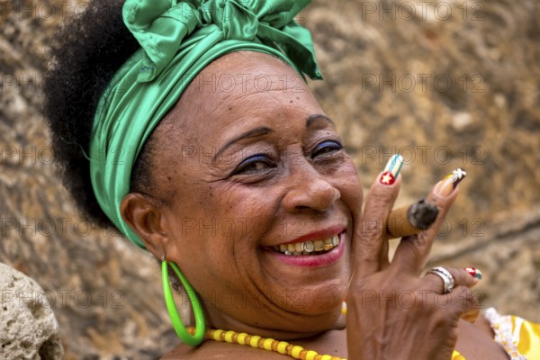 Old Cuban woman with green hair bow smokes a Havana cigar, Cuban woman with cigar and lacquered