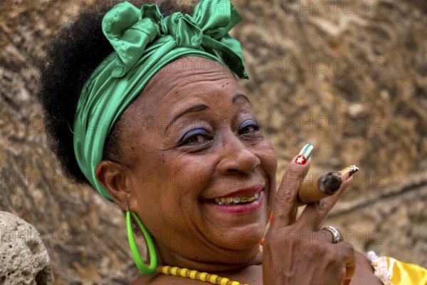 Old Cuban woman with green hair bow smokes a Havana cigar, Cuban woman with cigar and lacquered