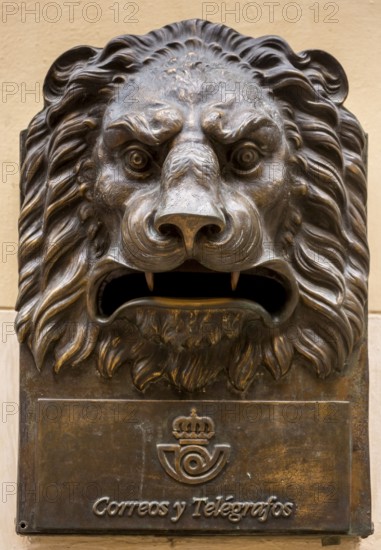 Tourist group in front of a bronze letterbox in the shape of a lion, Correos y Telegraficos, La