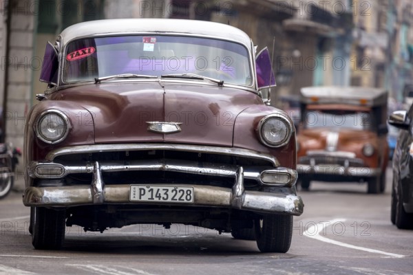 Brown vintage car in street scene, Old American street cruiser on the streets of Havana, taxi, La