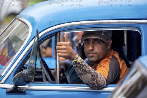 Taxi driver, blue vintage car in street scene, old American street cruiser on the streets of