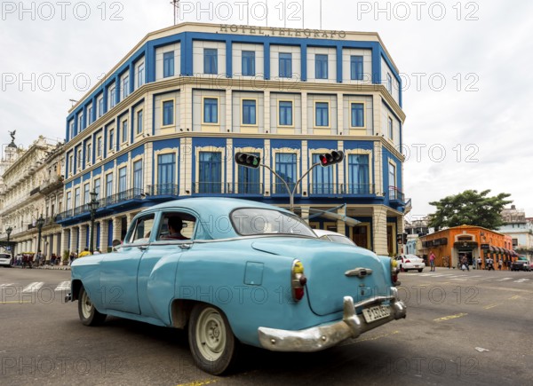 Turquoise-coloured vintage car in street scene, Old American street cruiser on the streets of
