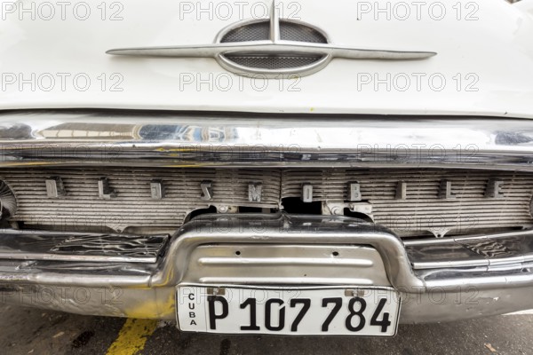 Radiator grille, white vintage car in street scene, Oldsmobile, Old American road cruiser on the