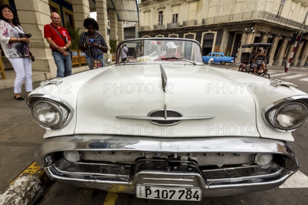 Radiator grille, white vintage car in street scene, Oldsmobile, Old American road cruiser on the