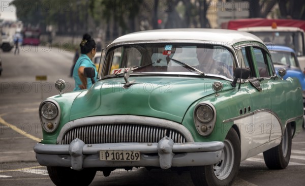 Green vintage car in street scene, Old American street cruiser on the streets of Havana, Taxi, La