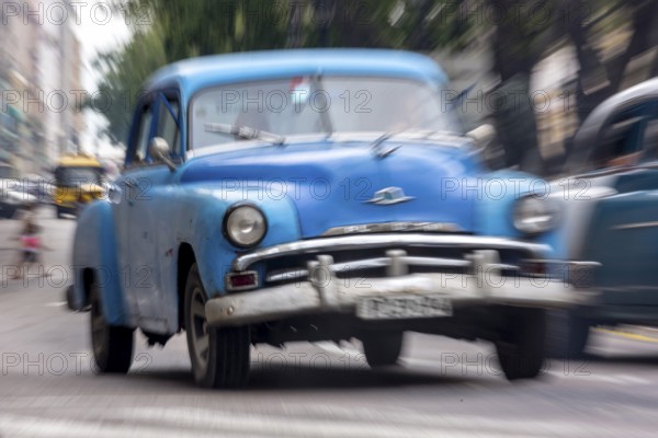 Blue vintage car in street scene, Old American street cruiser on the streets of Havana, Taxi, La