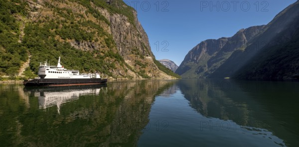 Excursion ship on a fjord, Flåm, Gudvangen, rock walls, trees, blue sky, Sogn og Fjordane, Norway,