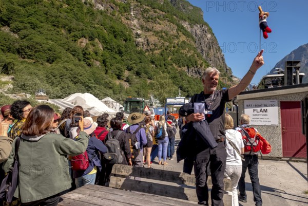 Travel guide with mascot at mountain hut station, mountains, construction site, construction site