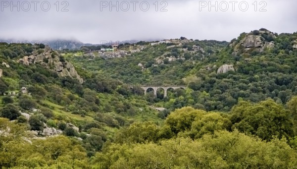 Sardinia, rugged granite mountains of Gallura, quarries and viaduct in hilly landscape, Olbia,
