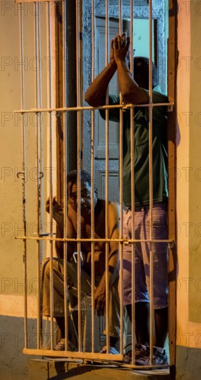 Paid car guards behind their barred windows in the old town of Trinidad, Street scene in the old