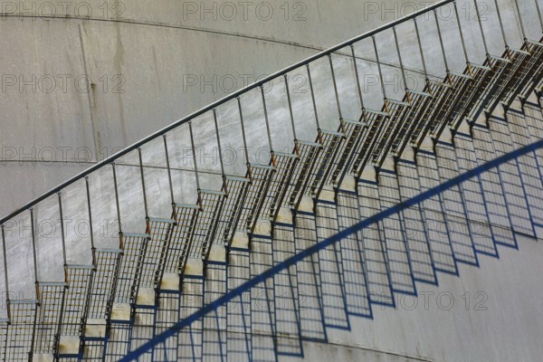 Close-up of a metal staircase with detailed shadows on the tank surface, elevated tank, chemical,
