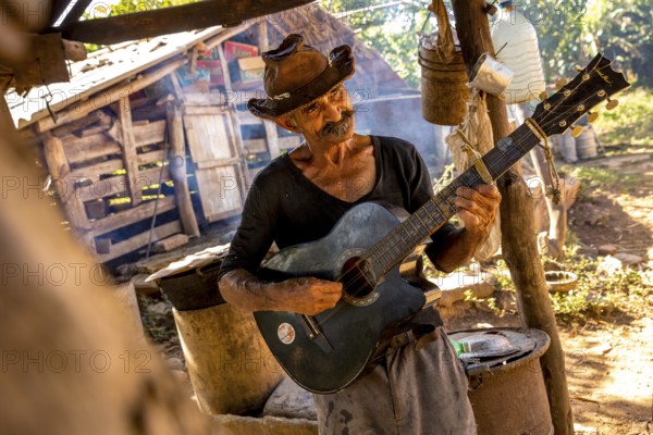 Sugar cane farmer in Valle de los Ingenios plays guitar for the tourists, Trinidad, Cuba, Sancti
