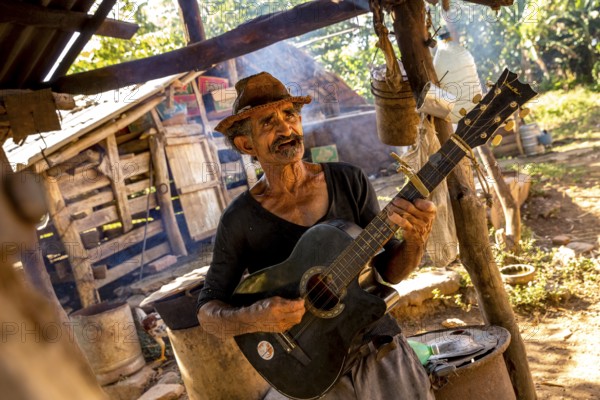 Sugar cane farmer in Valle de los Ingenios plays guitar for the tourists, Trinidad, Cuba, Sancti