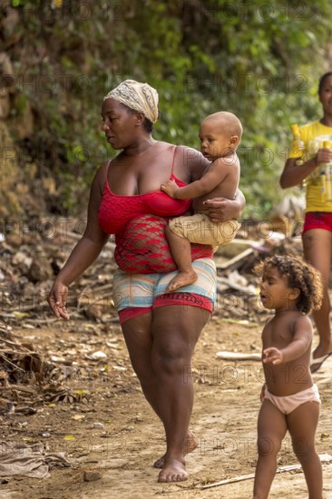 Mother with two children barefoot at a rubbish dump, poverty on the island of Cuba, Trinidad, Cuba,