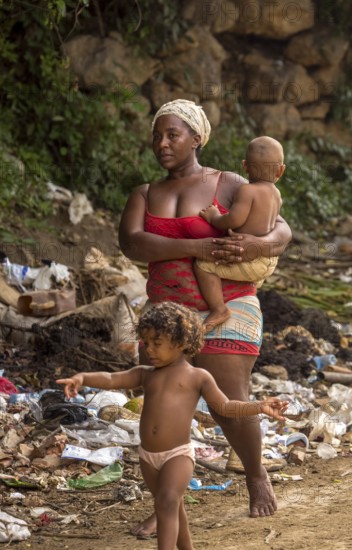 Mother with two children barefoot at a rubbish dump, poverty on the island of Cuba, Trinidad, Cuba,