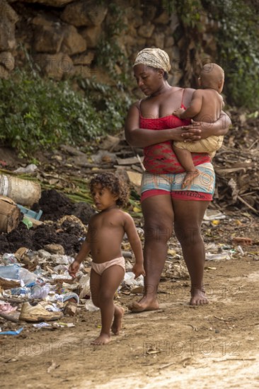 Mother with two children barefoot at a rubbish dump, poverty on the island of Cuba, Trinidad, Cuba,