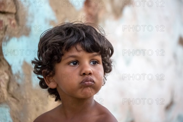 Little Cuban boy on the street in front of an old wall, Street scene in the old town of Trinidad,