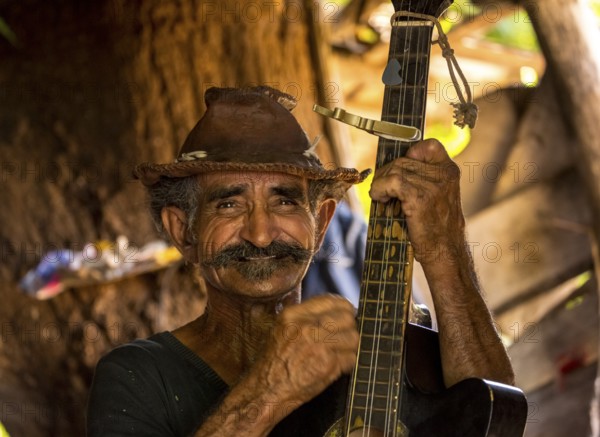 Sugar cane farmer in Valle de los Ingenios plays guitar for the tourists, Trinidad, Cuba, Sancti