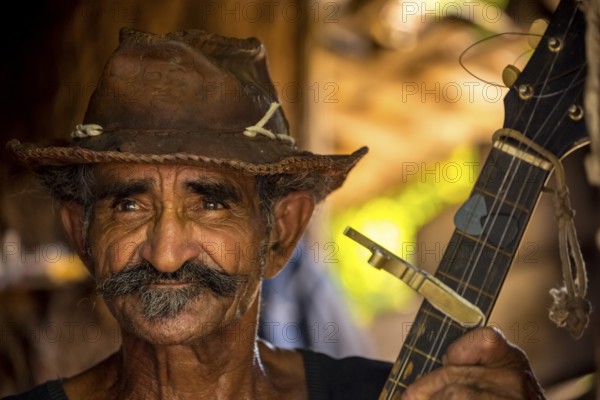 Sugar cane farmer in Valle de los Ingenios plays guitar for the tourists, Trinidad, Cuba, Sancti