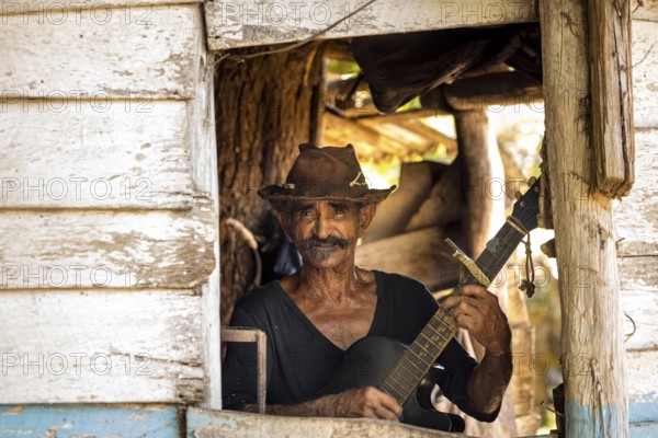 Sugar cane farmer in Valle de los Ingenios plays guitar for the tourists, Trinidad, Cuba, Sancti