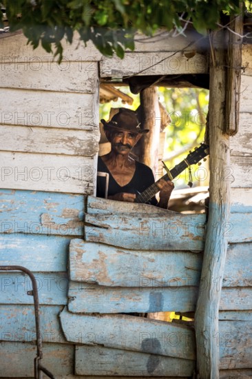 Sugar cane farmer in Valle de los Ingenios plays guitar for the tourists, Trinidad, Cuba, Sancti
