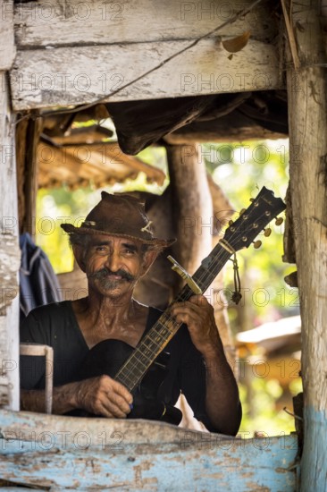 Sugar cane farmer in Valle de los Ingenios plays guitar for the tourists, Trinidad, Cuba, Sancti