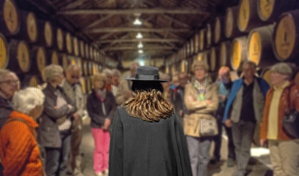 Group of visitors with traditional travel guide, port wine barrels, wine cellar of the Sandemann
