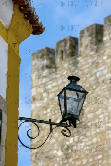 Picturesque small town Obidos, street lamp in front of city wall, Ãbidos, district Leiria,