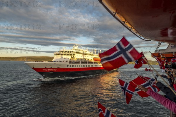 Tourists at the ship's railing, ship MS Finnmarken, Norwegian flags, Mehamn, Finnmark, Norway,