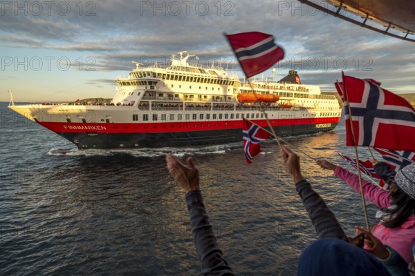 Tourists at the ship's railing, ship MS Finnmarken, Norwegian flags, Mehamn, Finnmark, Norway,