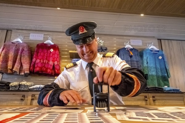Crew member stamps the mail on the mailboat, postman, ship officer, postal employee, postcard