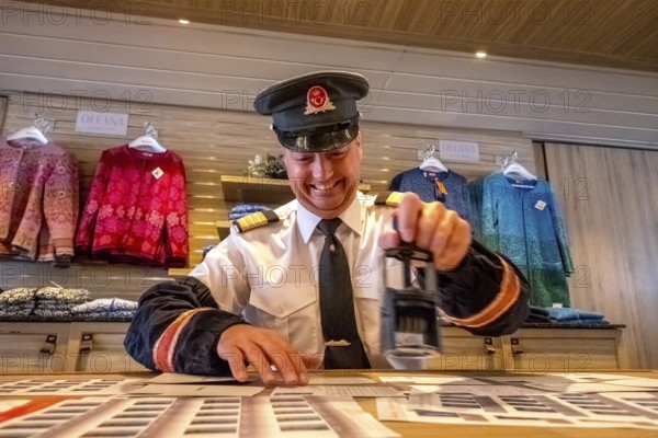 Crew member stamps the mail on the mailboat, postman, ship officer, postal employee, postcard