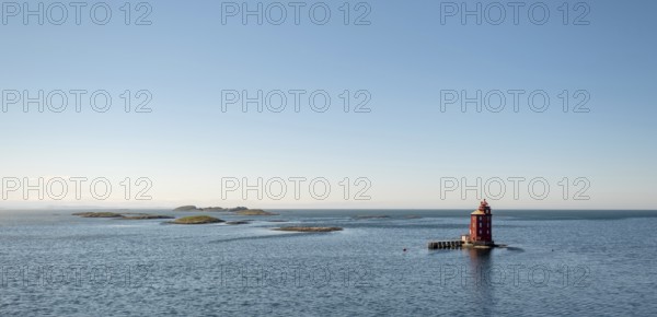 Kjeungskjær Fyr, red lighthouse, off the Norwegian coast on a small archipelago off Ã˜rland,