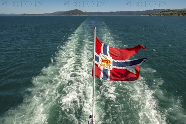 The post symbol on Norwegian flag of a Hurtigruten ship, foaming spray, Trondheimfjord, Agdenes,
