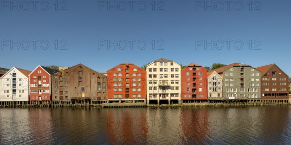 Warehouse city, picturesque colourful houses and commercial buildings on the river Nidelva, pile