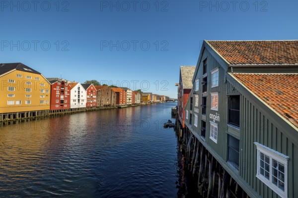 Warehouse city, picturesque colourful houses and commercial buildings on the river Nidelva, pile