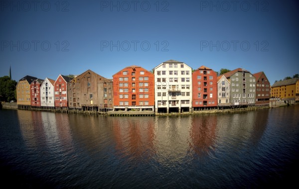 Warehouse city, picturesque colourful houses and commercial buildings on the river Nidelva, pile