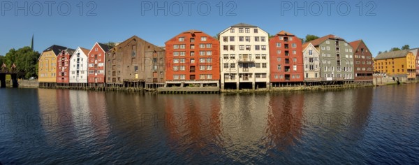 Warehouse city, picturesque colourful houses and commercial buildings on the river Nidelva, pile
