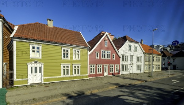 Colourful row of wooden houses in the city of Bergen, street with traffic lights, street lamp,