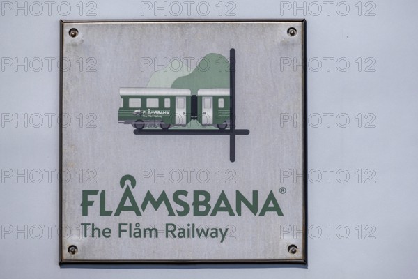 Journey on the Flam Railway, iron railway, white sign with green lettering Flåmsbana, The Flam