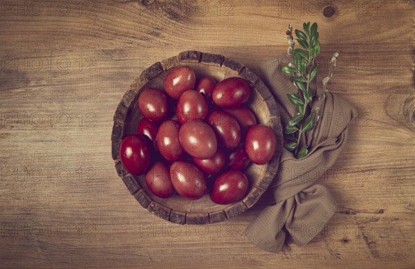 Painted eggs in a wooden bowl, red, painted madder dye, powder from the roots of endro, with onion