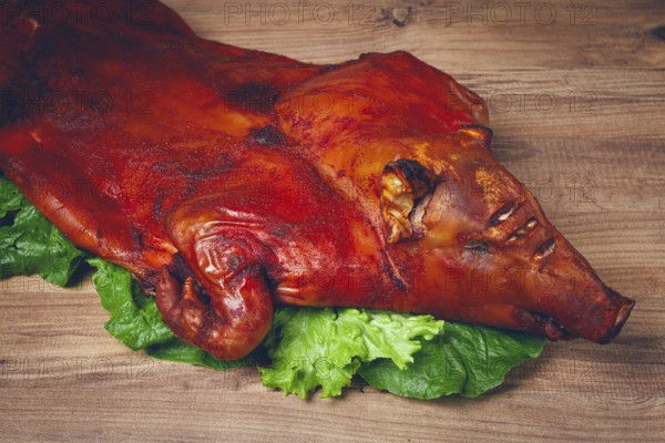 Baked, fried piglet, on a wooden table, no people, The whole piglet is baked and served on the