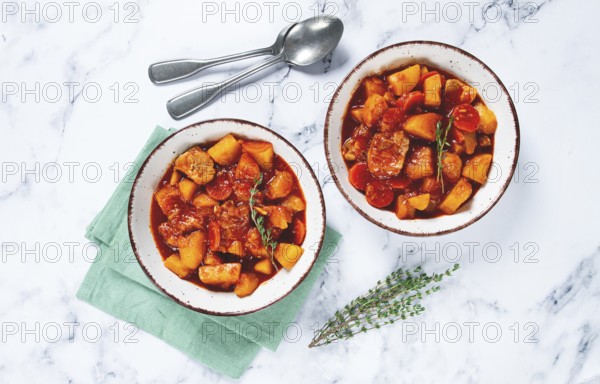 Meat goulash with potatoes and carrots, sweet peppers, in a saucepan, top view, traditional