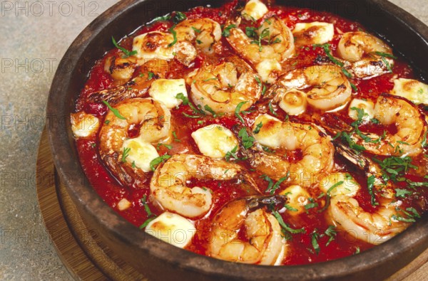 Saganaki with shrimp, in a clay pan, Greek dish, shrimp in tomato sauce, feta cheese, homemade, no