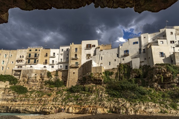 Houses above the cliffs on the town beach Spiaggia Llama Monachile in Polignano a Mare, Apulia,
