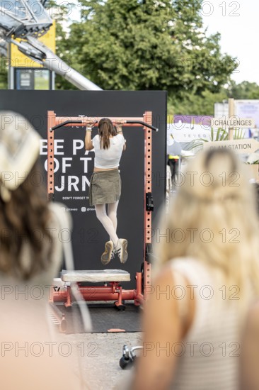 A visitor does pull-ups with make-up at the Superbloom Festival, Day 2 in the Olympic Park, Munich,