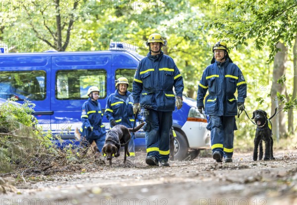 Dog handlers with rescue dogs from the Specialist Locating Group get ready for action, the sniffer