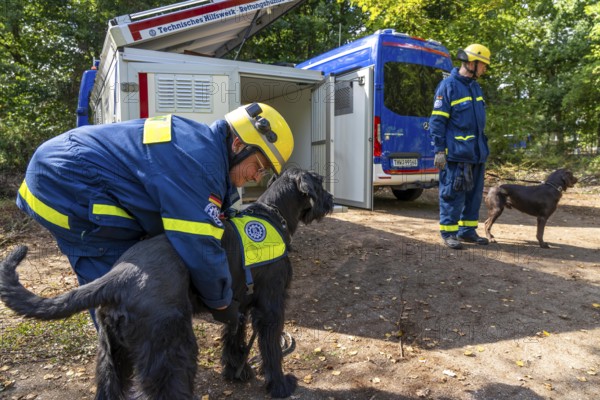 Dog handlers with rescue dogs from the Specialist Locating Group get ready for action, the sniffer