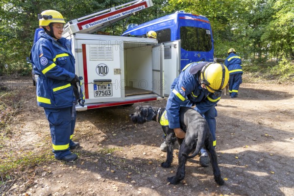 Dog handlers with rescue dogs from the Specialist Locating Group get ready for action, the sniffer